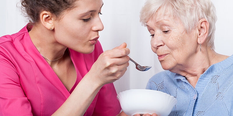Nurse feeding an older lady